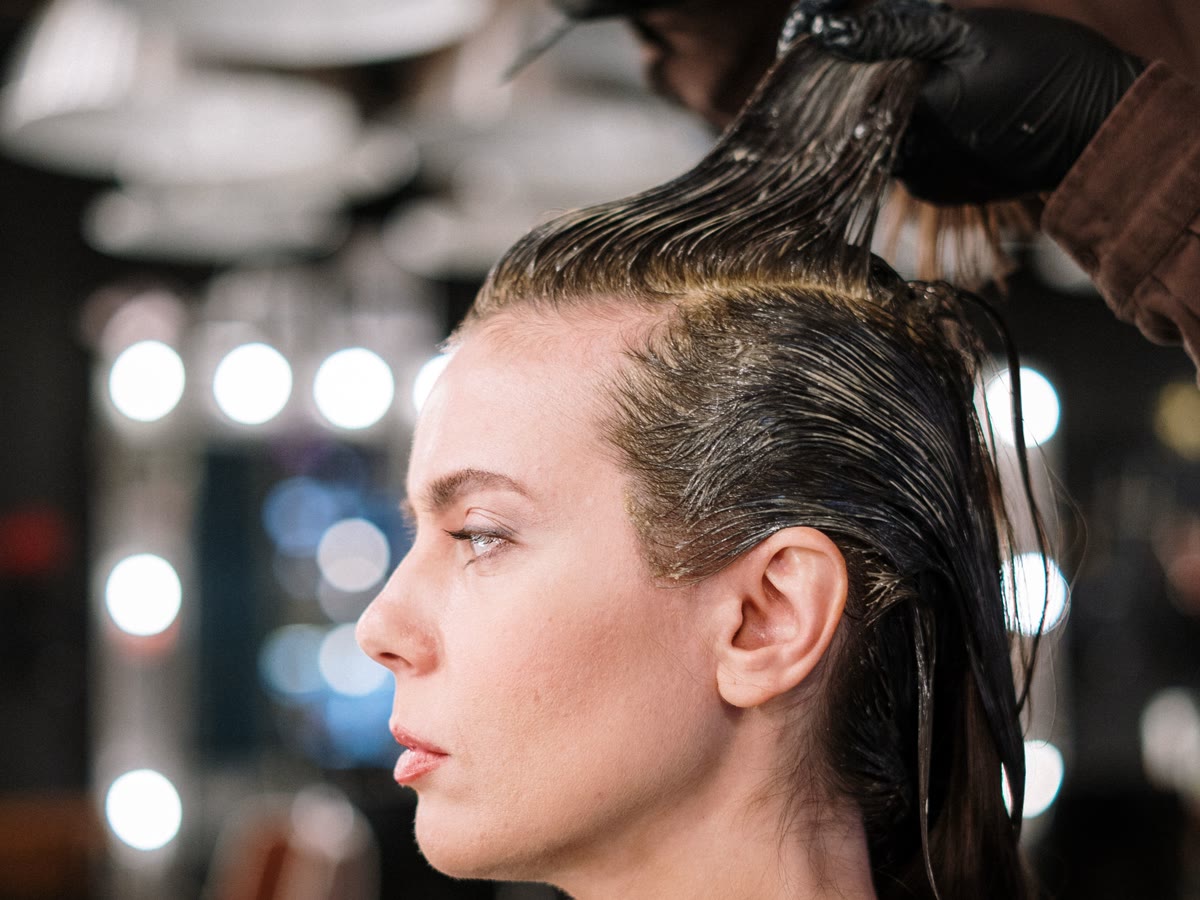 Color being brushed on at the root during a full color appointment at Velvet Fig Studio